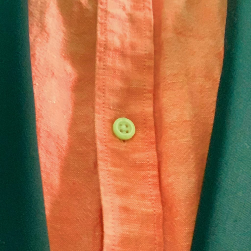 Close up photo of coral colored dress shirt